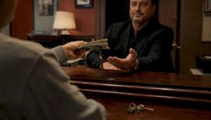 Hands exchanging cash and keys at jail booking window