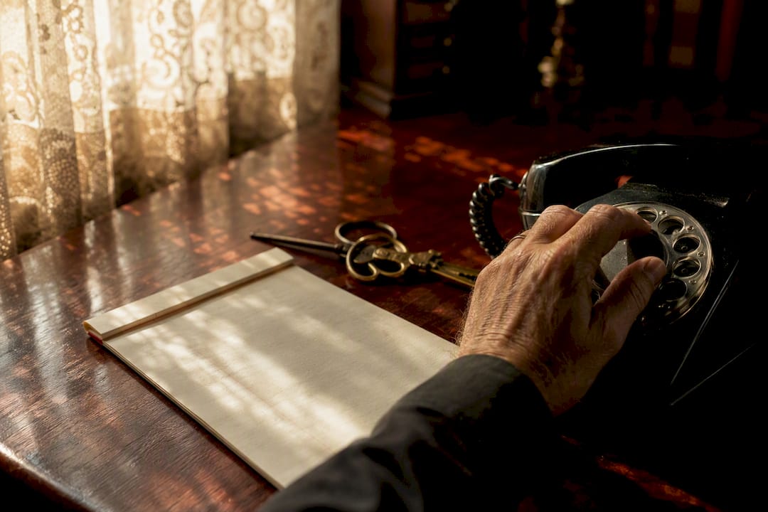 Hands dialing phone on desk