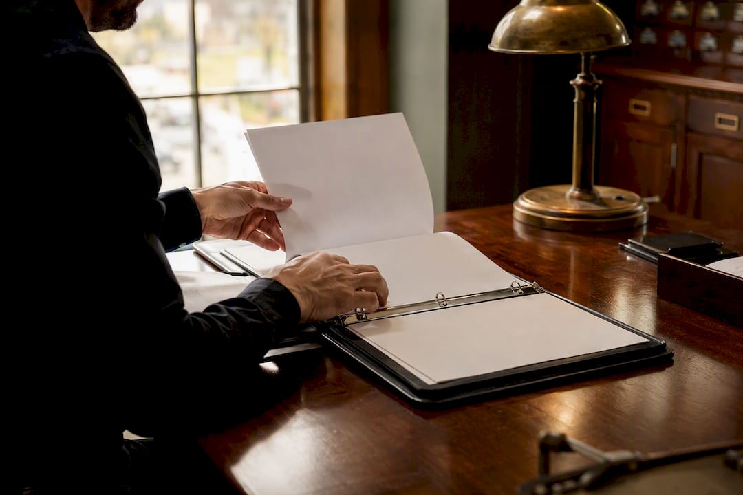 Hands organizing bond documents on desk