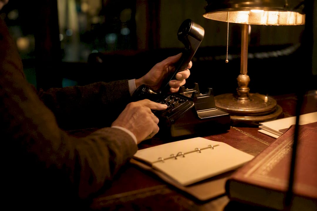 Bail agent on phone at office desk at night